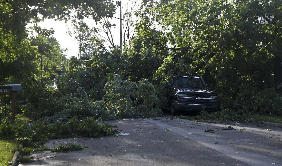 Downed trees block High Street on the east side of Portland on the morning of July 29. A storm that blew through Jay County early that day left a swath of damage in its wake. Trees and branches caused damage mainly in the corridor between High and Race streets, falling on houses and vehicles. “I’ve never seen so many vehicles getting crushed by storms like this one,” said Bubba Swoveland of Portland Street Department. (The Commercial Review/Ray Cooney)