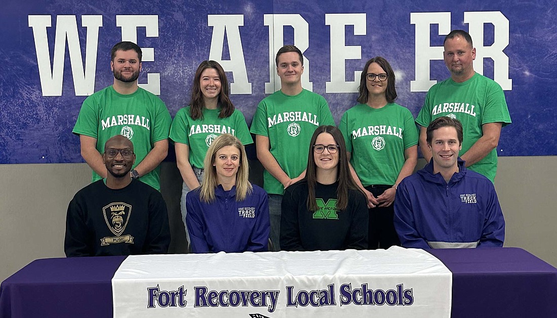 Fort Recovery High School senior Mara Pearson signed her national letter of intent to join the Marshall University track team on Dec. 23. Pictured in the front row from left are club coach Dakel Patterson of Push Athletics, FRHS coach Christy Diller, Mara and FRHS assistant coach Charlie Vasey. In the back row is Mara’s family: brother Clayton, sister Brooke Gaerke, brother Ross, mother Beth and father Steve. (Photo provided)