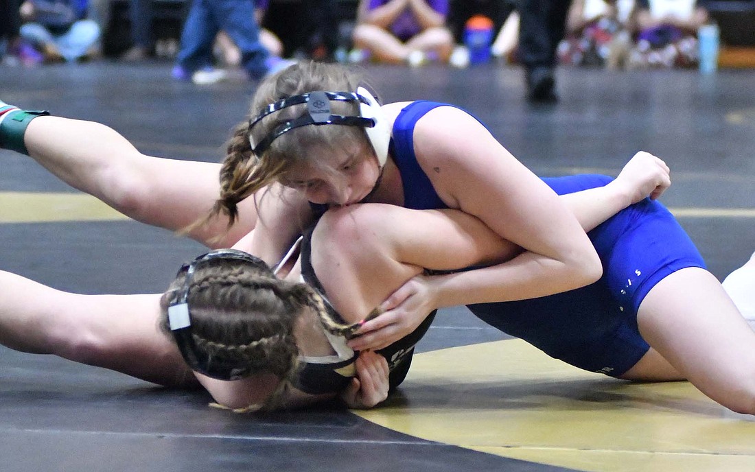 Emily Manor of JCHS rolls Rochester's Alexis Haughs onto her back during the 140-pound quarterfinal of the semi-state meet at Rochester on Friday. Manor drew a tough matchup as she will face defending state champion No. 1 Aleksandra Bastaic of Highland in the first round at Friday's state finals at Kokomo. (The Commercial Review/Andrew Balko)