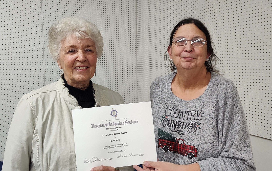 Mississinewa Chapter, Daughters of the American Revolution, recently awarded the Community Volunteer of the Year award. Pictured, chapter regent Kathy Selman (right) presents a certificate to Carol Smith, who started the free Thanksgiving dinners at Asbury United Methodist Church in Portland in 1991. In 2023, the all-volunteer crew prepared over 600 meals. (Photo provided)