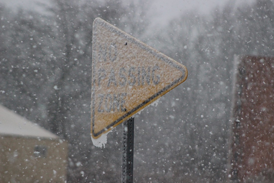 Jay County’s weather turned from rain to snow Friday, accumulating about an inch and a half of snow. Pictured, a no passing zone sign along Indiana 26 just outside of Portland is covered in snow Friday afternoon. (The Commercial Review/Bailey Cline)