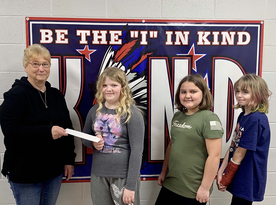 East Jay Student Council recently donated funds for the Jayland Angel Tree Project. The students organized a dress-up week to raise donations. Pictured, from left, Denise Brewster receives a check from Kinley Tarter, Violet Trinidad and Lily Denton. (Photo provided)