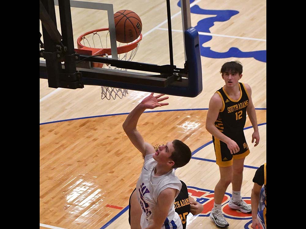 Eli Dirksen of Jay County High School comes down as the ball falls through the rim on a layup during a 54-19 win on Friday over South Adams. Dirksen, who recently started getting varsity minutes, led the Patriots with five rebounds and added seven points as well.  (The Commercial Review/Andrew Balko)