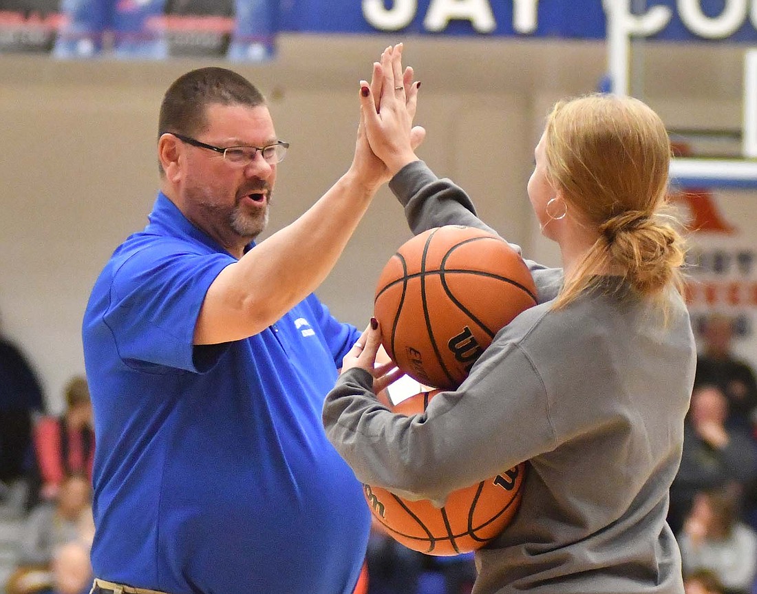 Athletics director Steve Boozier high-fives Daisy Muhlenkamp, who won a game of knockout during halftime of Friday’s Jay County High School boys basketball game. For winning, Muhlenkamp will get the opportunity to play knockout at the NBA All-Star game on Feb. 18 at Gainbridge Fieldhouse in Indianapolis. (The Commercial Review/Andrew Balko)