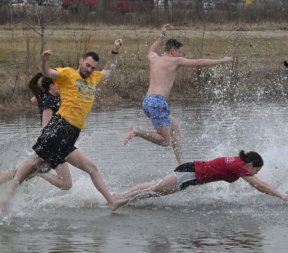 Clement Hortlander (yellow shirt), Bailey Hartman (black shirt), Connor Helsen (blue shorts) and Cara Brockman (red shirt), all of Muncie, jump into the pond just north of Accelerated Curing in Portland Saturday morning as part of the Splashin’ with a Passion: Peggy’s Plunge sponsored by Portland Fire Department and United Way of Jay County. Money raised by pledges will go to Jay County Special Olympics, Jay County Cancer Society, Jayland Homeless Shelter and other local non-profit organizations. (The Commercial Review/Andrew Balko)