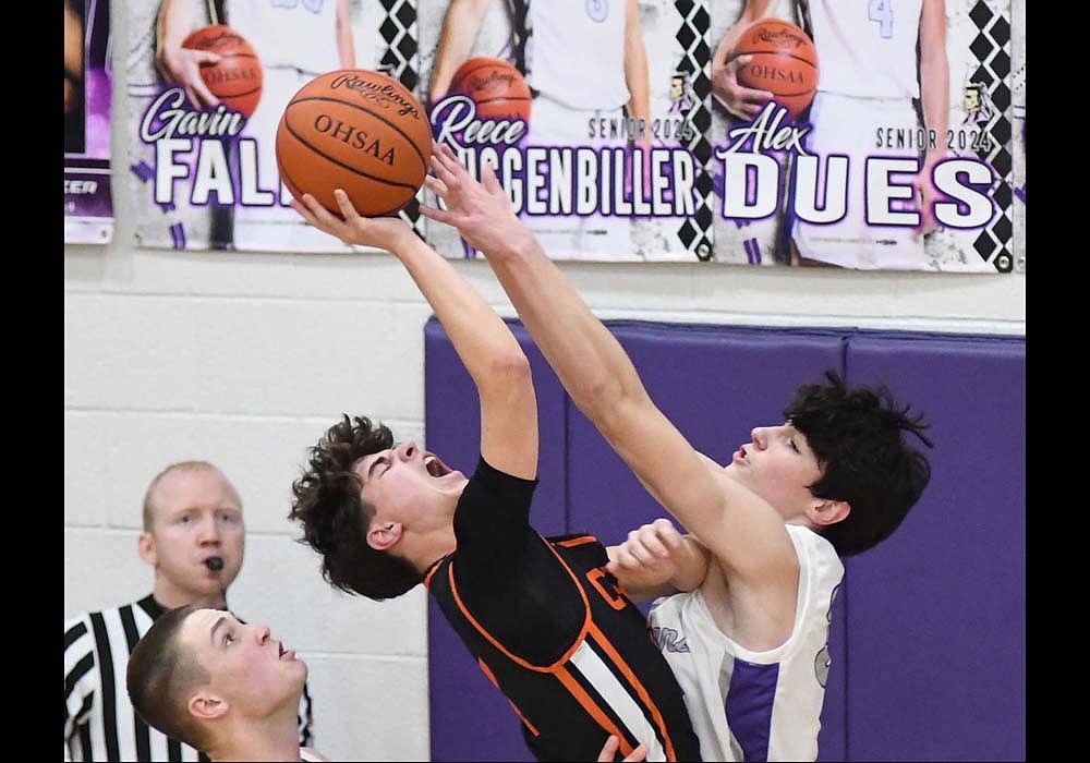 Fort Recovery’s Brody Barga gets his fingertips on a shot attempt by Minster’s Kole Richard during the second quarter of the Indians’ 66-58 loss. Richard finished with 17 points for the Wildcats. (The Commercial Review/Ray Cooney)