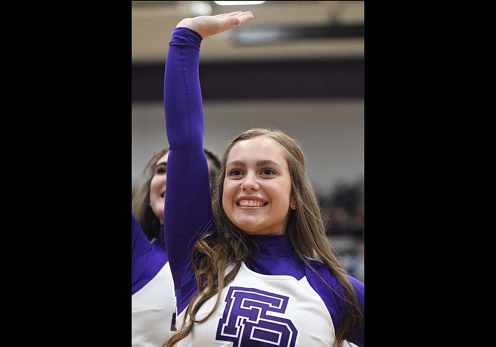Fort Recovery High School cheerleader Bailie Muhlenkamp, a junior, waves during the squad’s performance of its Universal Cheerleaders Association contest routine between the first and second quarters of the Indian boys basketball team’s game Friday against Minster. The cheerleaders will be honored for their Ohio Athletic Committee state championship at tonight’s basketball game against Newton Local. (The Commercial Review/Ray Cooney)
