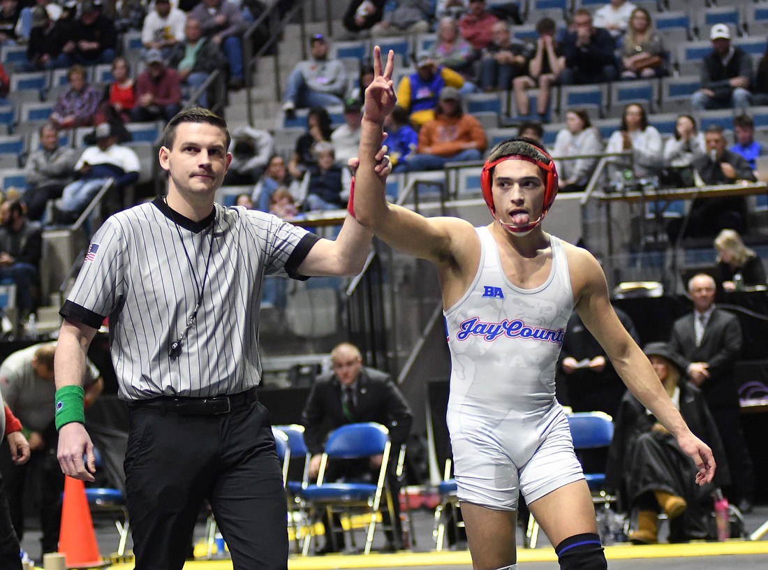 Jay County High School senior Tony Wood holds up two fingers while the referee raises his arm in victory after he beat Eastside’s 12th-ranked Linkin Carter 5-0 in the 138-pound semi-state championship match Saturday at Allen County War Memorial Coliseum in Fort Wayne. Wood, who is now undefeated at 44-0 and ranked fourth in the state, repeated as the semi-state champ. He and classmate Cody Rowles earned berths in the state tournament, which will be held Friday and Saturday at the Ford Center in Evansville. (The Commercial Review/Ray Cooney)