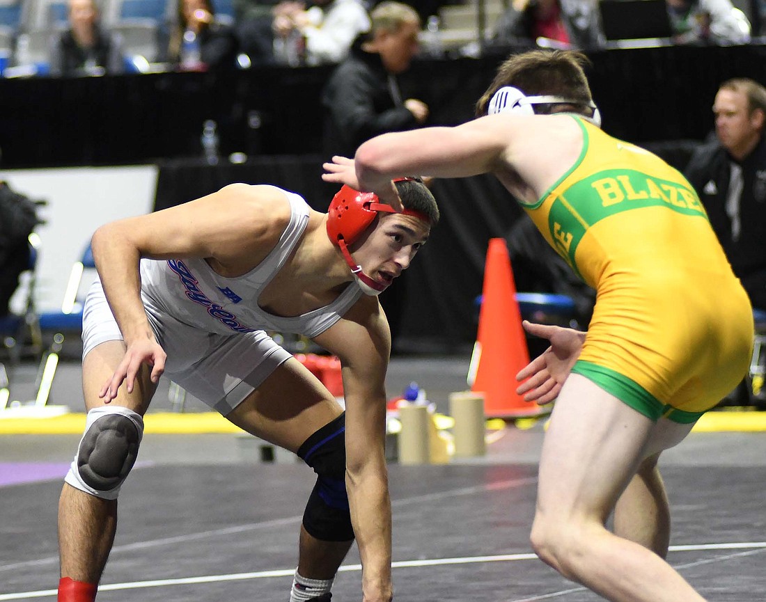 Jay County High School senior Tony Wood looks for an opportunity to shoot against No. 12 Linkin Carter of Eastside during their 138-pound semi-state championship match Saturday at Allen County War Memorial Coliseum in Fort Wayne. Wood (44-0) and teammate Cody Rowles will compete in the IHSAA Wrestling State Finals beginning at 6:30 p.m. Friday at the Ford Center in Evansville. Ranked fourth in the state, Wood is hoping to become the first JCHS wrestler in a decade to make it to the semifinals and have a chance to wrestle for a state championship on Saturday night. (The Commercial Review/Ray Cooney)