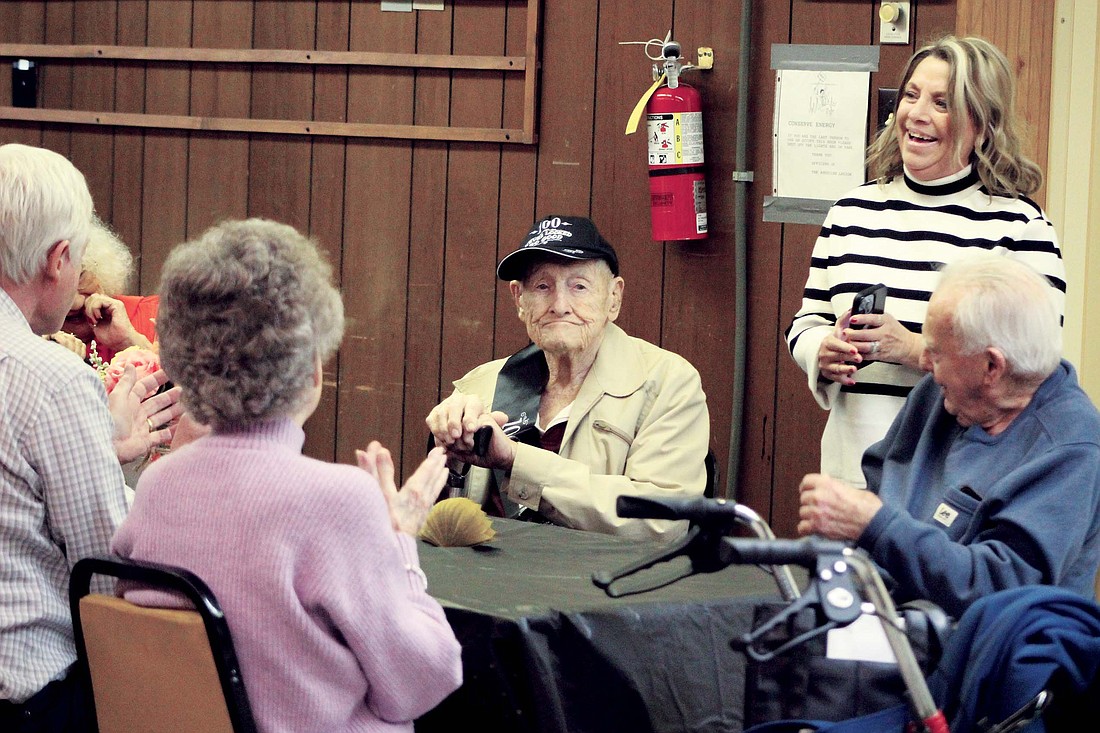 Mac Kelly celebrated his 100th birthday on Feb. 8. The longtime Portland resident married Patty Jo Derringer and worked at Sheller-Globe for 43 years. Pictured above, Kelly sits at American Legion Post 211 in Portland while his family sings to him at a surprise party Saturday. (The Commercial Review/Bailey Cline)