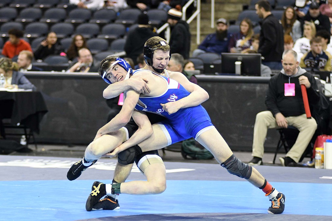 Jay County High School senior Cody Rowles drives his body into No. 7 Layne Horn of Rochester during their opening-round match in the 126-pound bracket of the IHSAA Wrestling State Finals on Friday night at the Ford Center in Evansville. Rowles, who is ranked 18th in the state, trailed 2-0 and 5-2 before scoring the final seven points of the match. He and classmate Tony Wood became the first Patriot duo to win wrestling state medals in the same season since Mason Winner and Gaven Hare in 2018. (The Commercial Review/Ray Cooney)