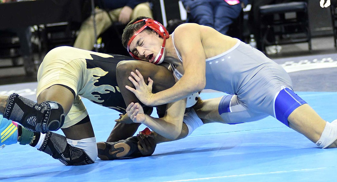 Fourth-ranked Tony Wood of Jay County High School grimaces as he tries to fight off No. 2 Kyrel Leavell of Warren Central during their 138-pound semifinal match Saturday in the IHSAA Wrestling State Finals at the Ford Center in Evansville. Wood lost to Leavell, the eventual state champion, and went on to finish in fourth place. (The Commercial Review/Ray Cooney)