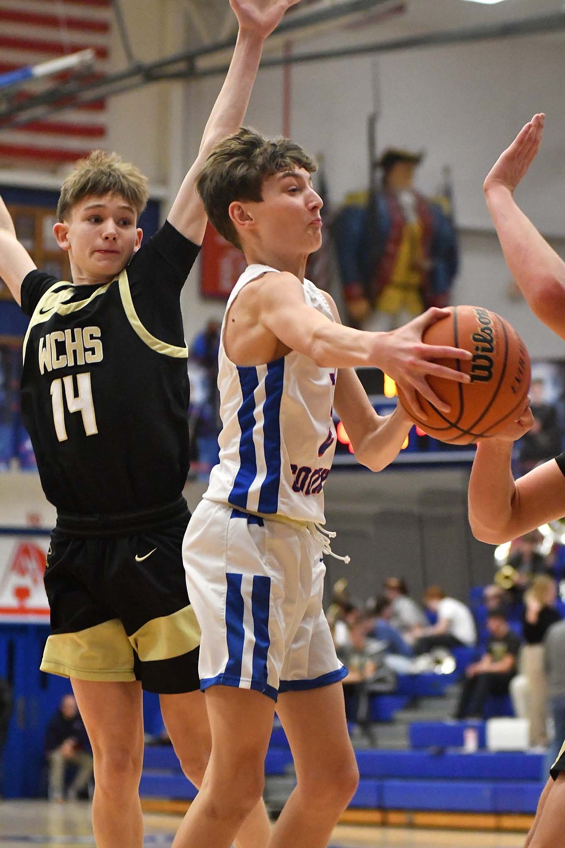 Jayden Comer, a freshman on the Jay County High School basketball team, makes a wrap-around pass past Winchester’s Austin Price (out of frame) in Tuesday’s 47-45 win for the Patriots. (The Commercial Review/Andrew Balko)