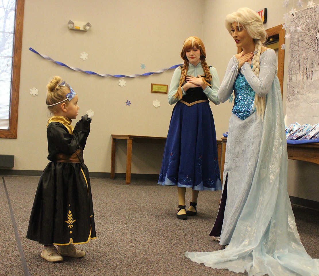 Zoey Huntsman interacts with Anna and Elsa from “Frozen” during the sing-along party Thursday at Jay County Public Library. (The Commercial Review/Bailey Cline)