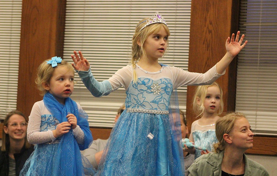 Cousins Kallie Carpenter, 3, and Victoria Glentzer, 7, dance along to “Let It Go” during the “Frozen” sing-along party Thursday at Jay County Public Library. (The Commercial Review/Bailey Cline)