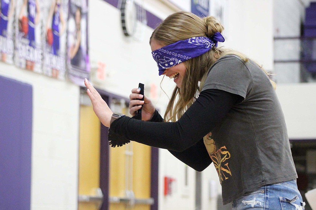 Sophomore Autumn Leuthold laughs as she walks blindfolded while playing Pin the Tail on the Donkey during Fort Recovery FFA’s Agricultural Olympics on Friday. Students competed in various activities, including bobbing for apples and musical chairs, during the event in Fort Recovery High School’s gymnasium. (The Commercial Review/Bailey Cline)