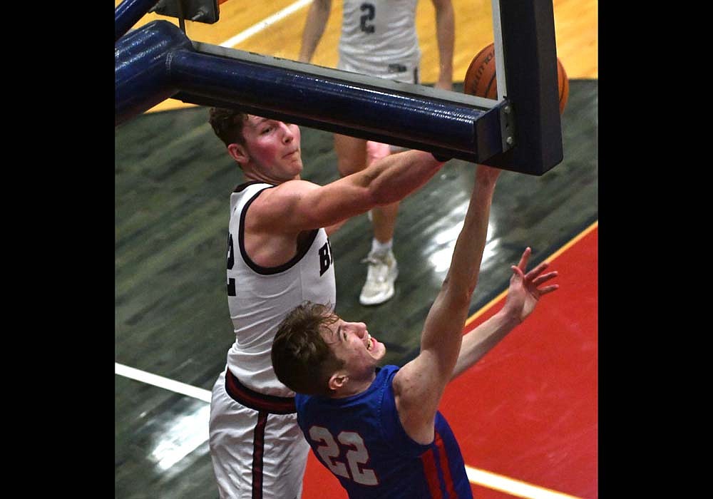 Jay County High School's Ben Crouch gets blocked by Job Hoffman of Bellmont on a reverse layup during the Patriots’ 60-31 loss on Friday. Crouch was Jay County's leading scorer with six points at the time, but contact on the play resulted in Crouch hitting his head on the baseline wall and he was removed from the game. (The Commercial Review/Andrew Balko)