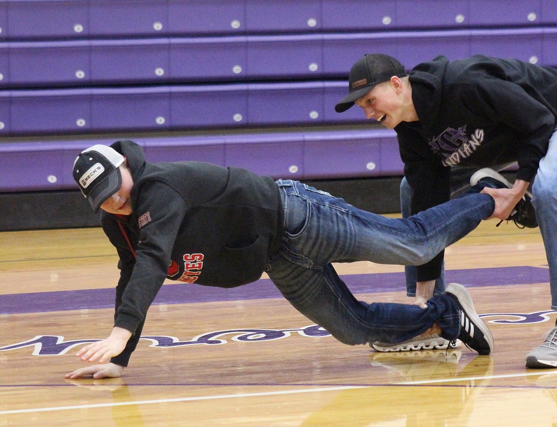 Fort Recovery FFA closed out its celebration of National FFA Week on Friday with Ag Olympics. Pictured above, Fort Recovery High School juniors Drew Backs and Even Evers stumble in the two-person race. Despite the setback, Evers and Backs won the event. Below, Junior Gage Zehringer steals a seat from freshman Brady Evers during the musical chairs portion of Fort Recovery FFA’s Agricultural Olympics on Friday. (The Commercial Review/Bailey Cline)