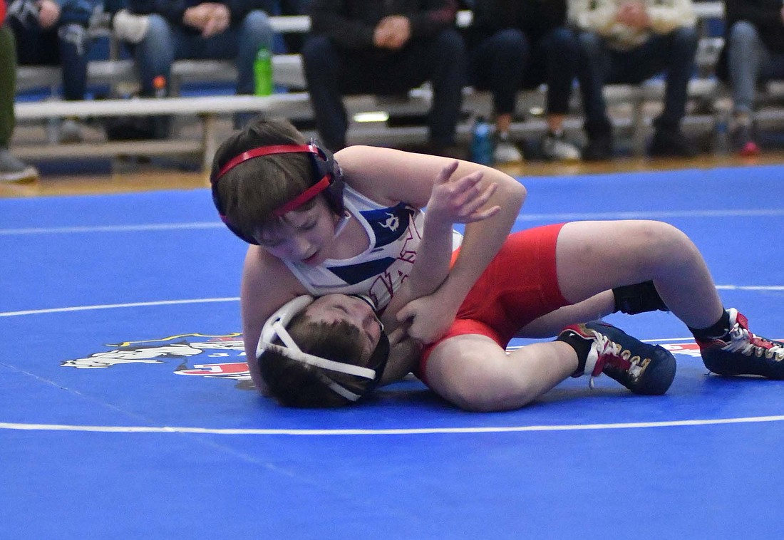 Mitchell Byrum of Jay County Junior High School nearly pins Bluffton’s Boone Sprunger in the 75-pound match Thursday. Byrum led off with a 9-6 decision to get the Patriots started as they beat Bluffton 62-57. (The Commercial Review/Andrew Balko)