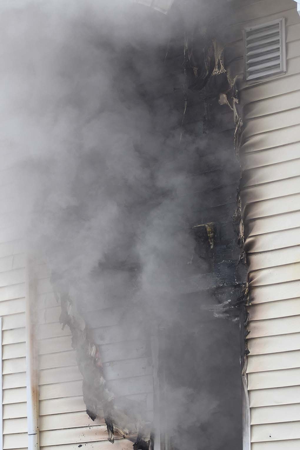 Smoke pours from a west-facing window at 409 W. Main St., Portland, on Monday morning. Portland firefighters took about a half hour to put out the fire that was mostly contained to the kitchen. For details, see Capsule Reports. (The Commercial Review/Ray Cooney)