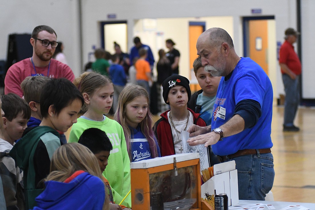 A group of local third graders learns about bees with Rick Root during one of a series of agriculture-related displays set up Thursday in the Jay County Junior-Senior High School auxiliary gym. The event, which also included Jay County FFA, Minnich Poultry, Jay County Soil and Water Conservation District and others, was part of Ag Week activities. (The Commercial Review/Ray Cooney)