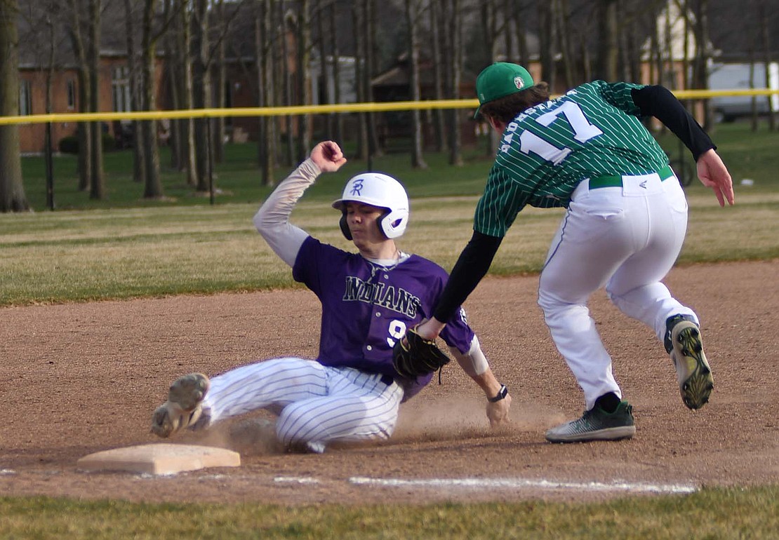 Reece Wendel, a sophomore at Fort Recovery High School, slides into third base safely after taking off from first base on a Troy Homan sacrifice bunt on March 25. The Indians haven’t played in over a week as rainy weather has kept them off the field. (The Commercial Review/Andrew Balko)