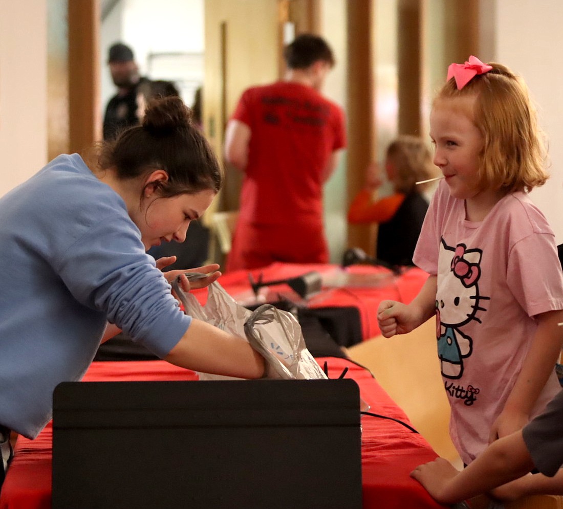 Mazie Zaugg selects her prize Saturday during the Easter egg hunt at Asbury United Methodist Church in Portland. The event included a variety of activities for children, including egg decorating and coloring pages. (The Commercial Review/Lina Lingo)