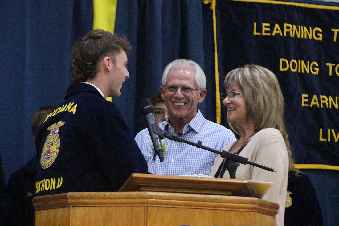 FFA president Nick Lyons congratulates Dennis and Marianne Horn for winning the Ag Hall of Fame award during Jay County FFA’s annual banquet Friday. The Horns, who have run their family farm together through the years, were honored for their agricultural and volunteer efforts in the community. (The Commercial Review/Bailey Cline)