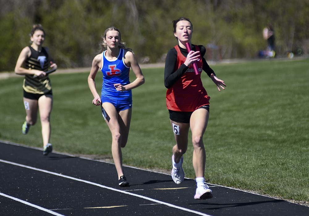 Jay County High School senior Makinsey Murphy reels in Julie Dargo of Wapahani on the final lap of the 4x400-meter relay Saturday at the Wapahani Raider Relays. Murphy's rally on the final leg of the race gave the Patriots their only event win of the meet and lifted them to the championship. (The Commercial Review/Ray Cooney)