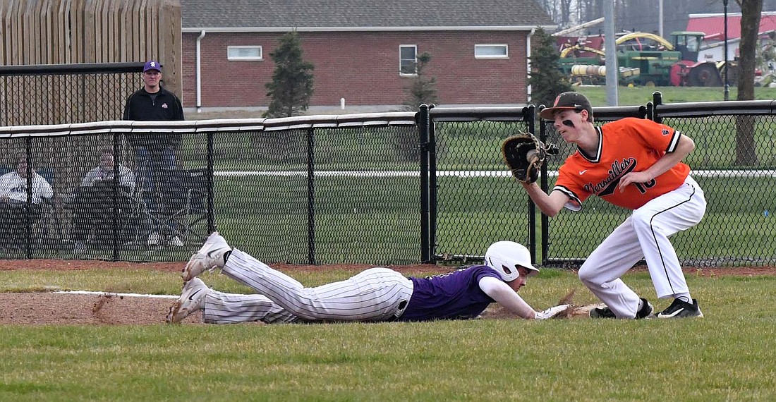 Riggs Tobe of Fort Recovery High School dives back into first base on a pickoff attempt by the Versailles Tigers on Tuesday’s game. Tobe was one of four Indians to record a hit before the game got suspended due to weather in the top of the fifth inning. (The Commercial Review/Andrew Balko)