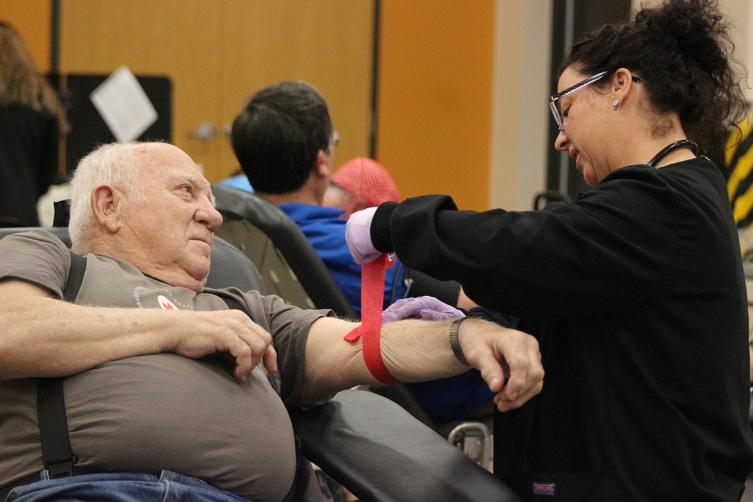 Billy Sipe of rural Portland chats with American Red Cross volunteer Tami Metz of St Marys, Ohio, while she wraps his arm Tuesday during the blood drive at Jay Community Center. (The Commercial Review/Bailey Cline)