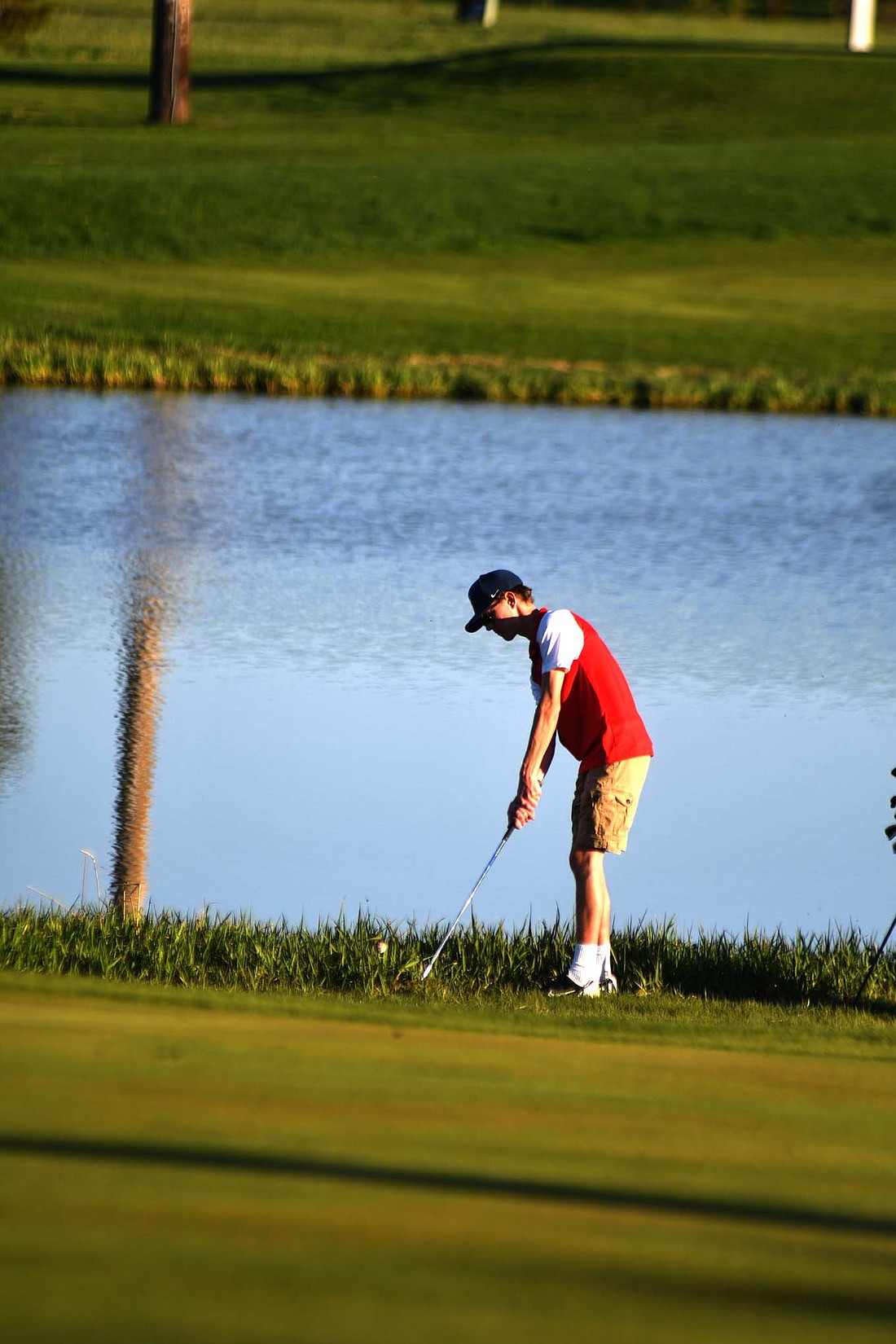 Luke Fugiett chips out of the weeds on the 358-yard, par-3 seventh hole at Portland Golf Club during the Jay County High School boys golf team’s 159-167 defeat at the hands of the Delta Eagles on Monday. (The Commercial Review/Andrew Balko)