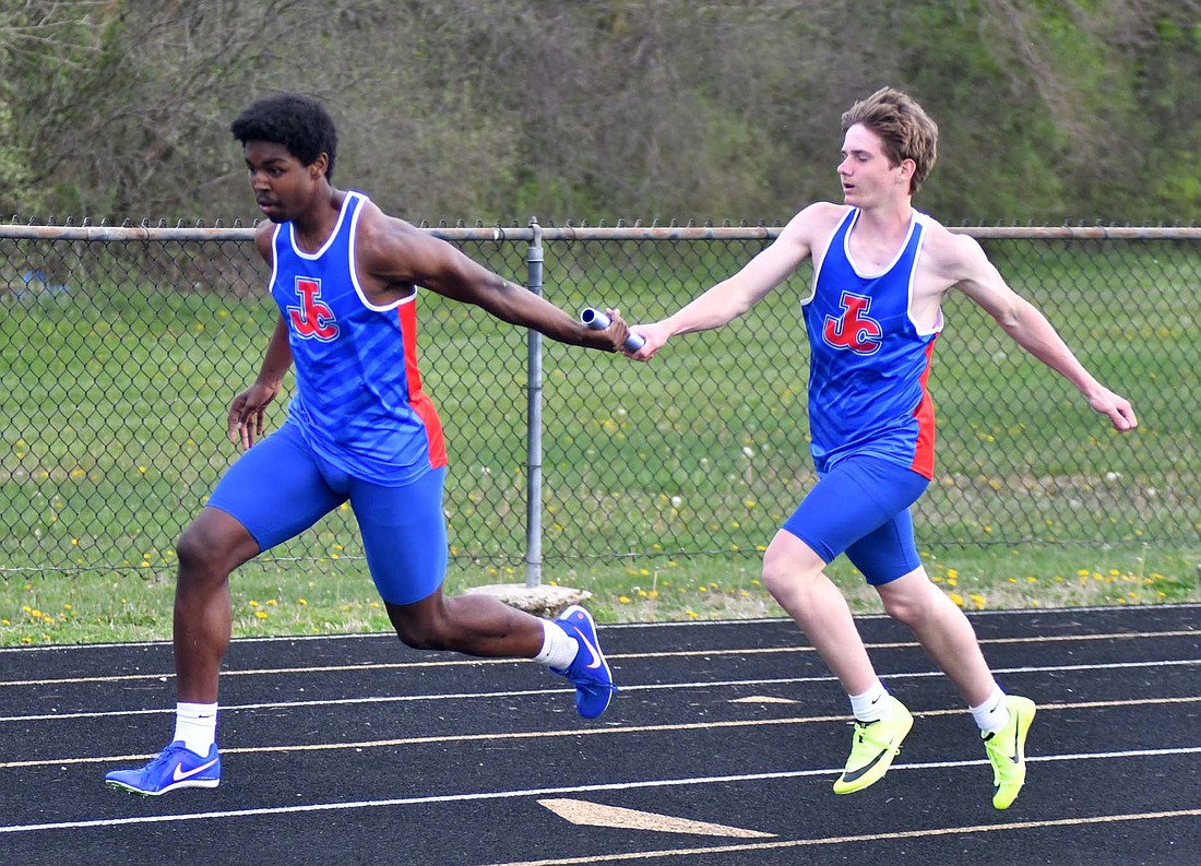 Blake Collins hands off the baton to Caden Gambill during the 4x100-meter relay Tuesday when the Jay County High School track team hosted the Bluffton Tigers at West Jay Elementary School. Gambill had one of three first-place finishes for the boys in the 97-26 loss. (The Commercial Review/Andrew Balko)