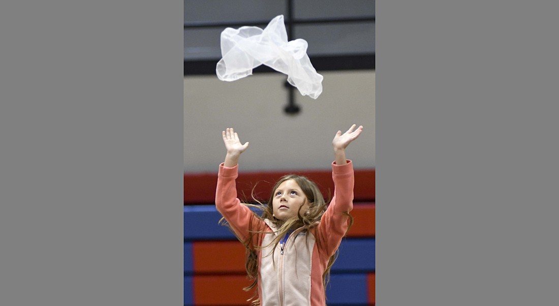 Skye Ingram tosses a scarf in the air to mimic snow during Thursday morning’s rehearsal for the East Elementary School first grade spring program at East Jay Elementary School. The students performed a variety of musical numbers to go along with the story “The Day the Crayons Quit.” (The Commercial Review/Ray Cooney)