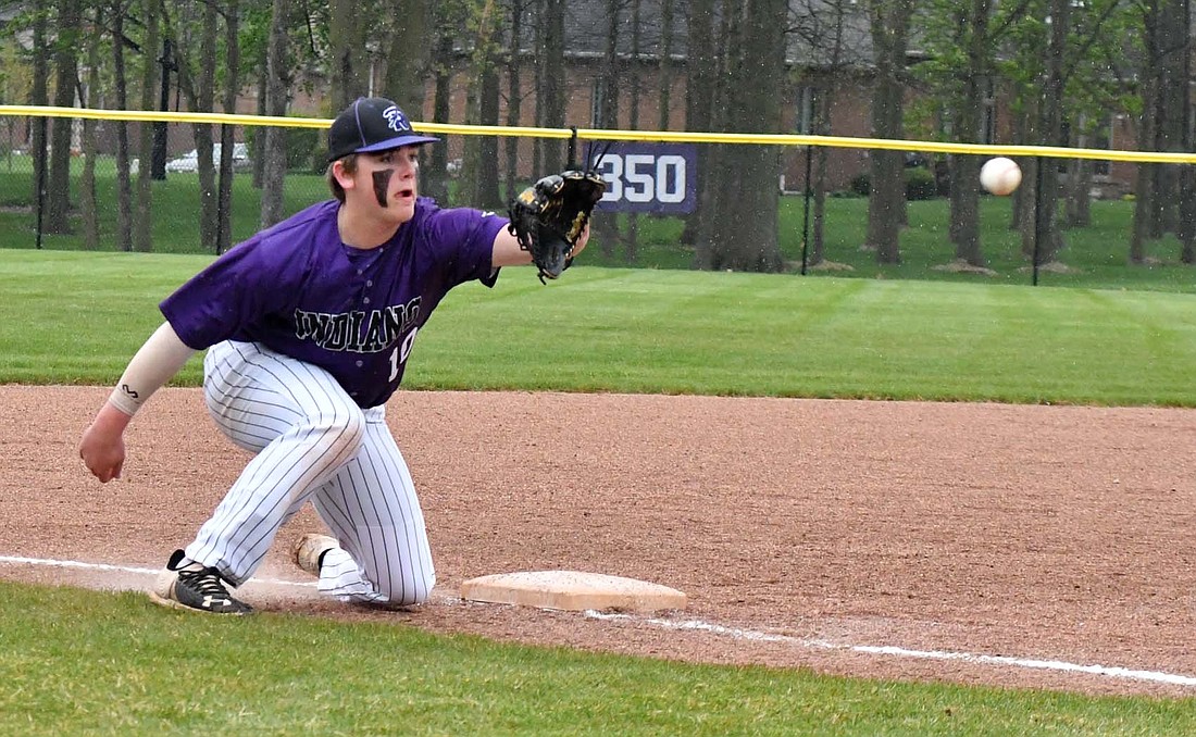 Fort Recovery High School sophomore Caden Homan receives a throw down from Riggs Tobe during the Indians’ 2-0 win over St. Henry on Tuesday. Tobe and Homan successfully recorded the out as Tobe had to throw from his knees after blocking a curveball. (The Commercial Review/Andrew Balko)