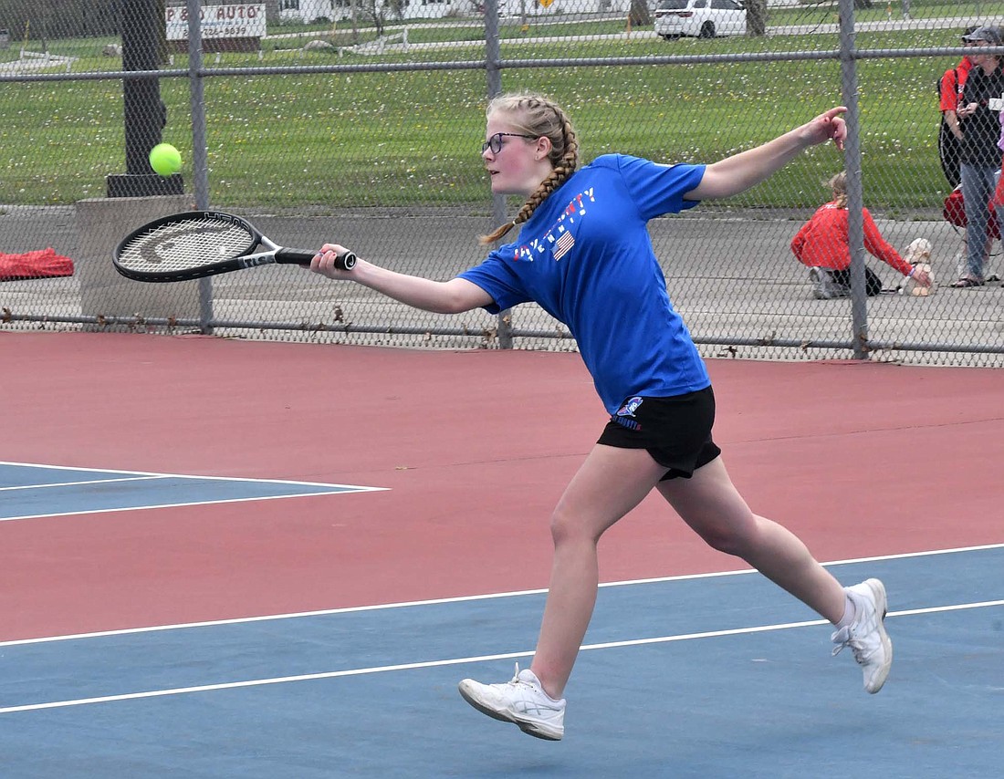 Jay County Junior High School’s Maddie Clark reaches to hit a forehand during a doubles match against the Adams Central Jets on Saturday. (The Commercial Review/Andrew Balko)