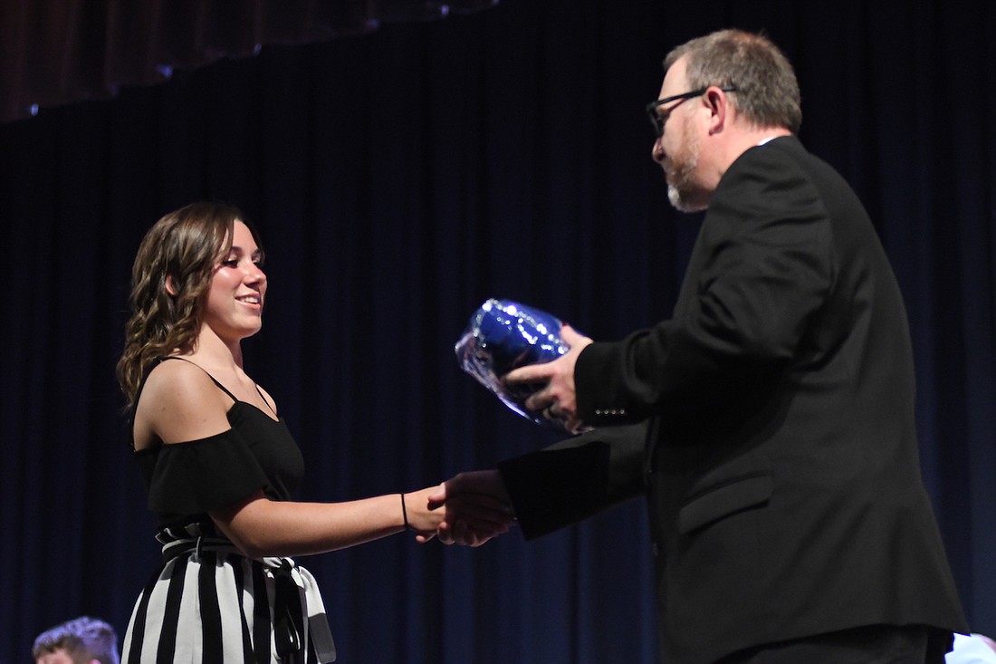 Mady Fraley receives her athletic letter blanket Monday from Jay County High School principal Chad Dodd during Honors Night. Fraley also was honored for receiving an associate’s degree from Ivy Tech Community College. She won the Jane E. Switzer Memorial Scholarship and the Better Business Bureau Students of Integrity Scholarship, among others. (The Commercial Review/Ray Cooney)