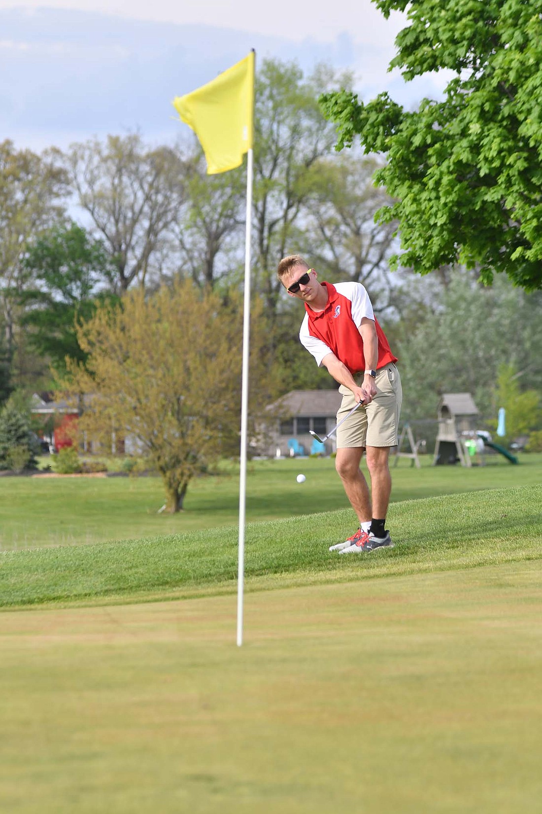 Jay County High School senior Gage Sims chips onto the green on the 16th hole at Portland Golf Club on Thursday. Sims put together the second-best score of 40 strokes to lead the Patriots to wins over both Bluffton and Bellmont. (The Commercial Review/Andrew Balko)