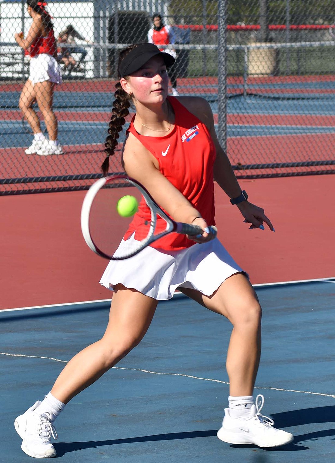 Jay County High School No. 1 singles tennis player Brenna Haines hits a forehand during her match against Muncie Central’s Isabel Quirk on Tuesday. The Patriots senior dropped the first game of the set, but then rallied to beat Quirk 6-1, 6-1 as Jay County secured the 4-1 victory. (The Commercial Review/Andrew Balko)