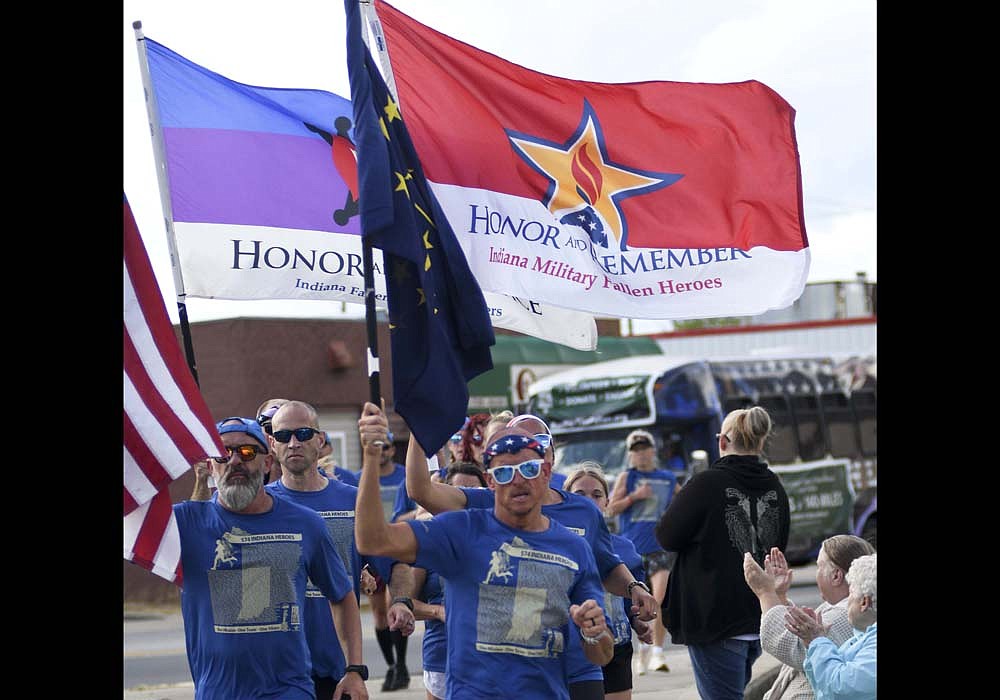 Eric Butcher (center) and CR Dillon (left) of Portland lead the Indiana Run for the Fallen into Freedom Park at the close of the first day of the event Friday. Runners made their way from Fort Wayne to Portland on Friday, stopping 52 times to honor those who died as a result of serving in the War on Terror including Operation Iraqi Freedom, Operation Enduring Freedom and Operation New Dawn. They will depart from Freedom Park at 7 a.m. today as they run 58 miles to Anderson. On Sunday, they will travel 30 miles from Anderson to Indianapolis. (The Commercial Review/Ray Cooney)