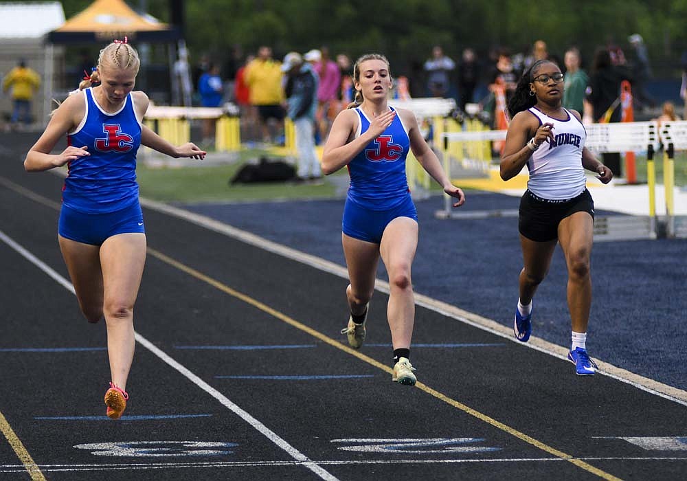 Jenna Dues (left) and Ariel Beiswanger of Jay County High School cross the finish line side by side Tuesday during the 200-meter dash as part of the sectional meet at Delta. They teamed with Morgan DeHoff and Matilda Mende to earn the Patriots’ only title of the event in the 4x100 relay. (The Commercial Review/Ray Cooney)