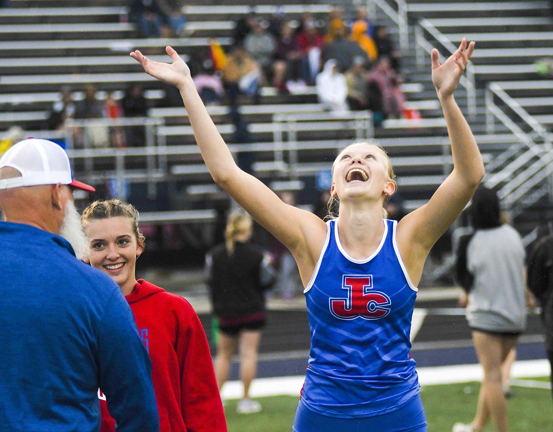 Jay County High School junior Jenna Dues celebrates alongside teammate Ariel Beiswanger and coach Joe Imel after the Patriots won the sectional championship in the 4x100-meter relay Tuesday at Delta. Joining Dues and Beiswanger on the winning team were Matilda Mende and Morgan DeHoff. For more on the meet, see page 8. (The Commercial Review/Ray Cooney)