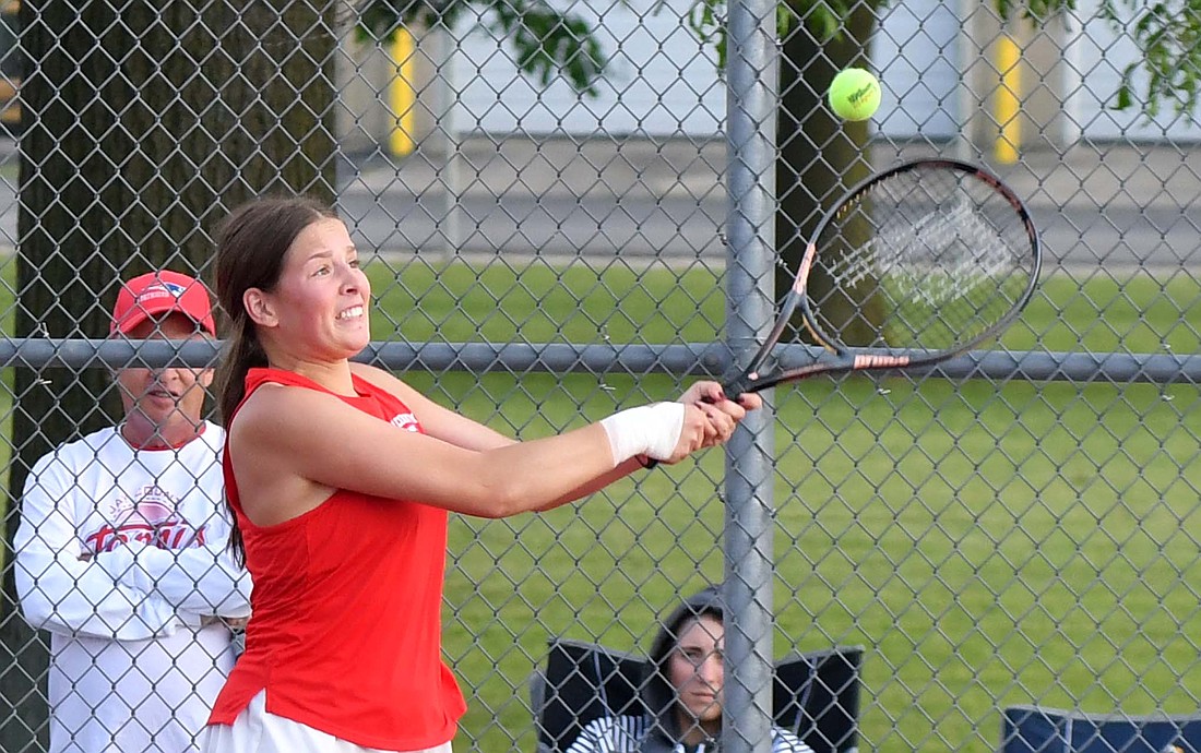 Lucie Henneaux, an exchange student at Jay County High School, grimaces as she hits a backhand on Wednesday's 4-1 victory in the sectional opener against Randolph Southern. Henneaux and Zion Beiswanger teamed up to win the No. 2 doubles match 6-0, 7-6 (8-6) to set up a date with the Union City Indians on Thursday. (The Commercial Review/Andrew Balko)