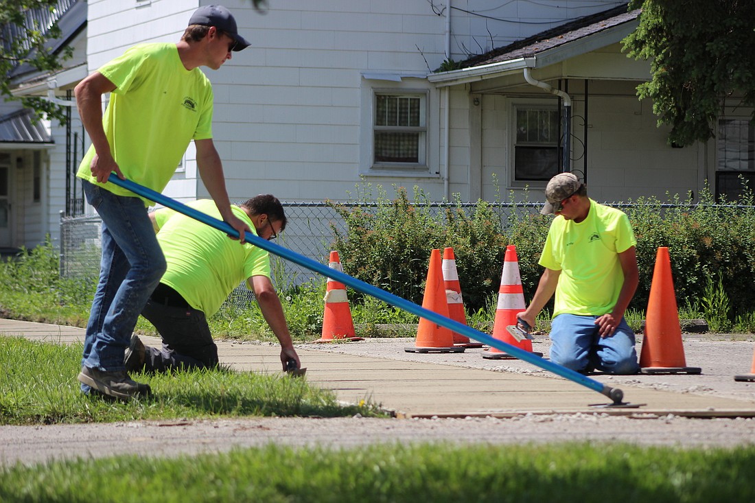 Portland Street Department workers Joe Jackson, Crist Counterman and Kody Muhlenkamp smooth down a new sidewalk Tuesday along Wayne Street near its intersection with Walnut Street. (The Commercial Review/Bailey Cline)