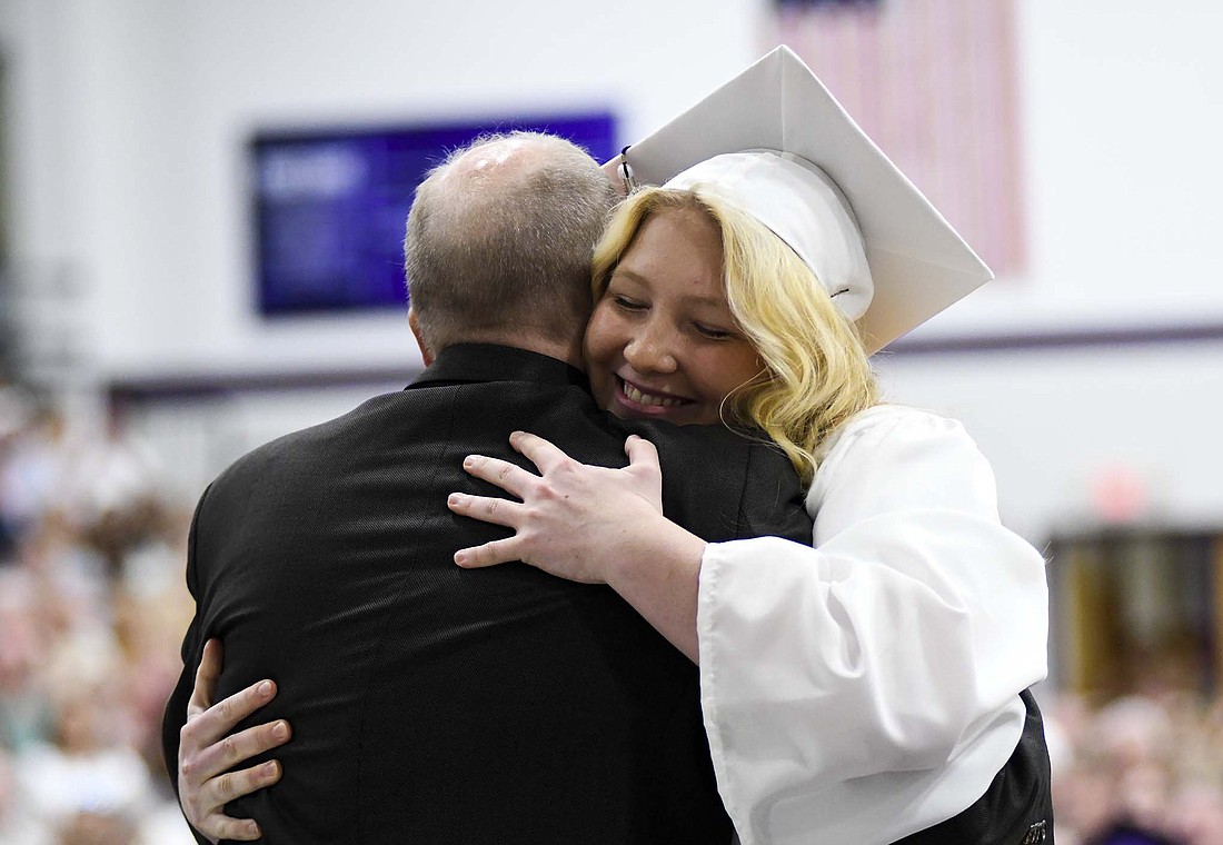 Joscie LeFevre hugs her dad, school board member Greg LeFevre, after he presented her with her diploma Sunday during Fort Recovery High School’s graduation ceremony at Fort Site Fieldhouse. (The Commercial Review/Ray Cooney)