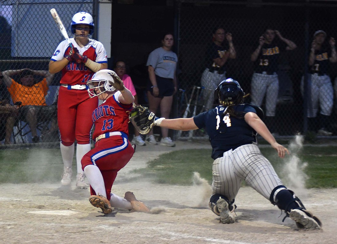 Riah Champ, a senior at JCHS, avoids Ava Montero’s tag by inches in a steal of home plate to beat Delta by a 13-3 mercy rule in the  IHSAA Class 3A Sectional 24 opener. (The Commercial Review/Andrew Balko)