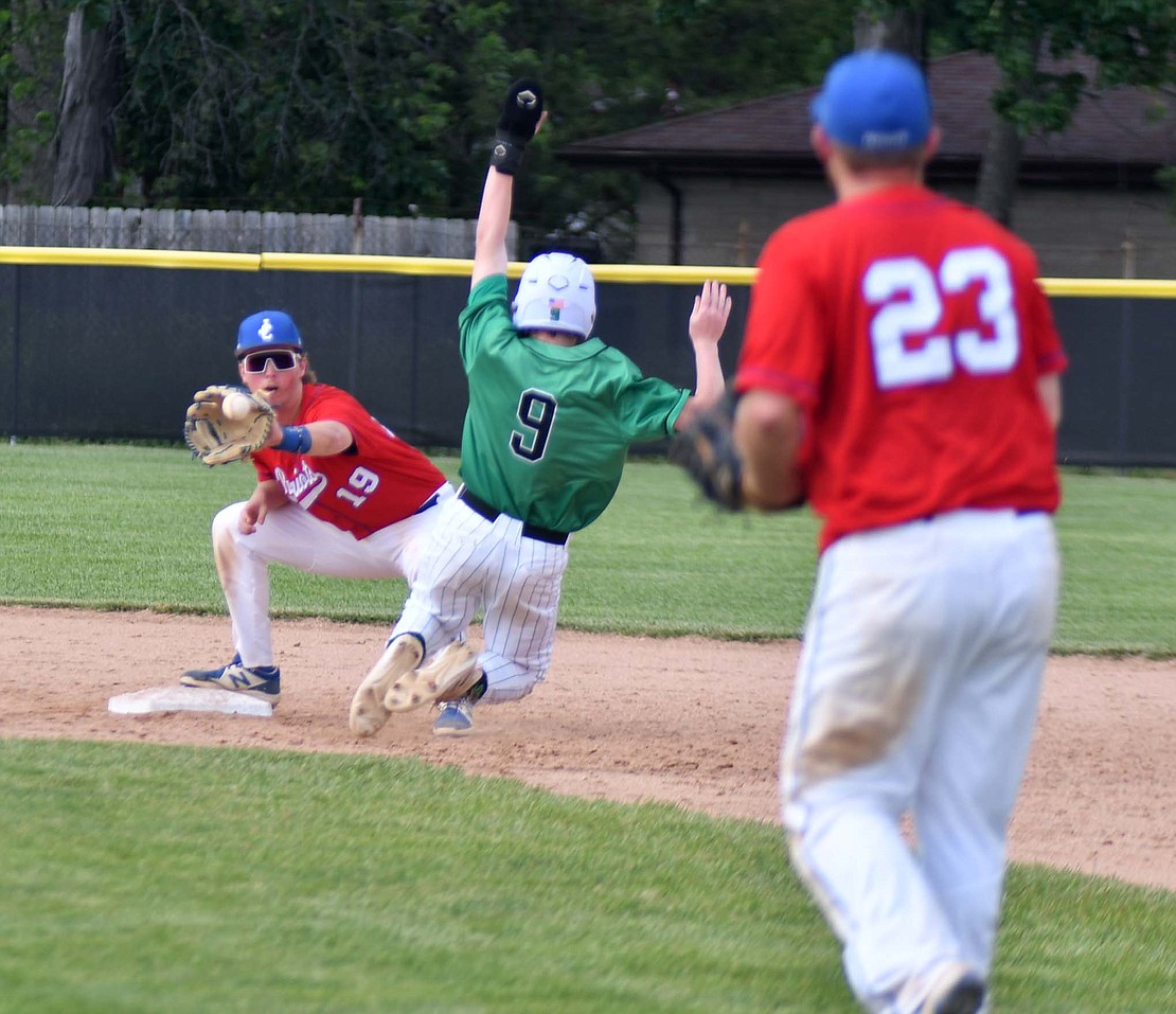 Jay County High School seniors Sam Myers (19) and Ryne Goldsworthy (23) connect to get the lead runner out at second base during the Patriots' 13-12 loss to New Castle in Saturday's sectional semifinal at Yorktown. The two provided an offensive spark with five combined hits and eight RBIs, including two go-ahead runs, but it wasn't enough as the Trojans walked off the Patriots for a second year in a row (The Commercial Review/Andrew Balko)