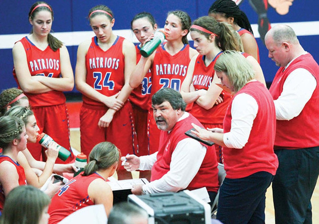 Coach Kirk Comer addresses his team in a timeout during his second stint as head of the Jay County High School girls baseball team. Comer left the Patriots due to work commitments but is coming back to coach at Bishop Dwenger in the 2024-25 season. (The Commercial Review/Chris Schanz)