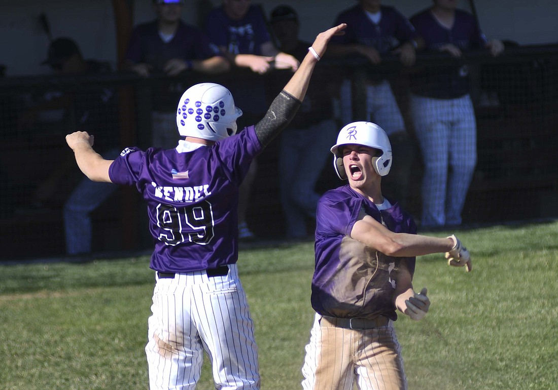 Fort Recovery High School's Mason Diller celebrates with Reece Wendel (99) after both scored on a double by Caden Grisez during the fifth inning of the Indians' 14-4 regional semifinal victory over Montpelier on Thursday at Elida. Diller was a pinch runner for Caden Homan. The Indians will return to Elida to play Leipsic in the regional championship game at 5 p.m. Friday. (The Commercial Review/Ray Cooney)