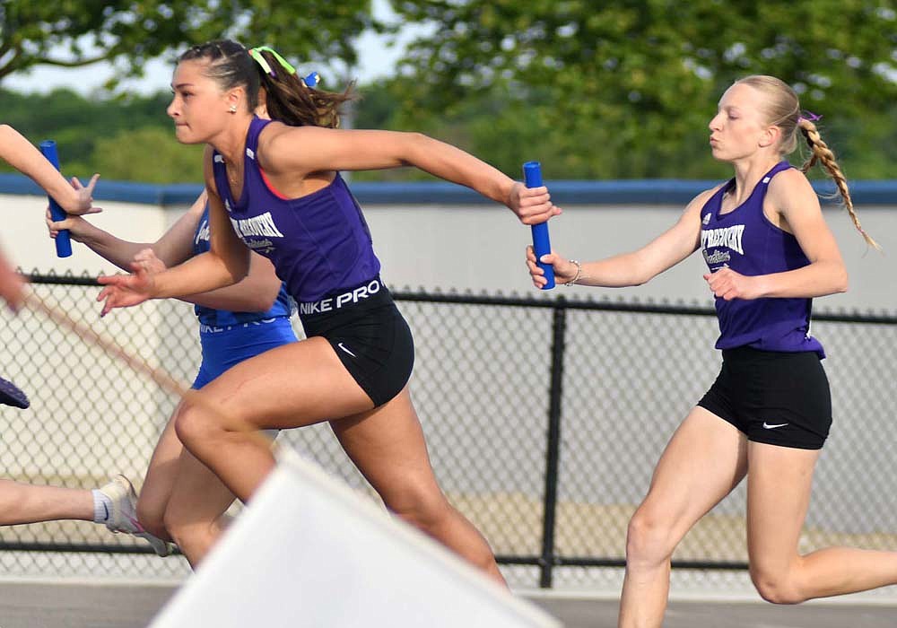 Fort Recovery High School sprinters Paige Guggenbiller (left) and Anna Roessner execute the first exchange during the 4x100-meter relay at the OHSAA Division III state track and field tournament at Welcome Stadium in Dayton on Friday. The Indians completed their redemption tour with a podium-worthy finish of 49.67 seconds to take fourth-place after being disqualified from the state finals for an early start in 2023. (The Commercial Review/Andrew Balko)